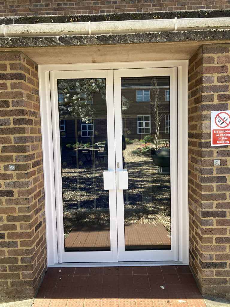 New secure white double doors at an education facility by Taurus Boston